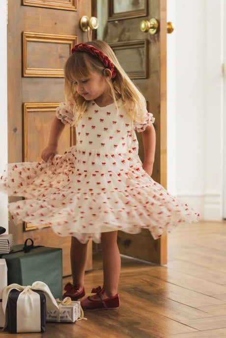 Girl wearing white bows dress and the Noralee Braided Headband | Ruby