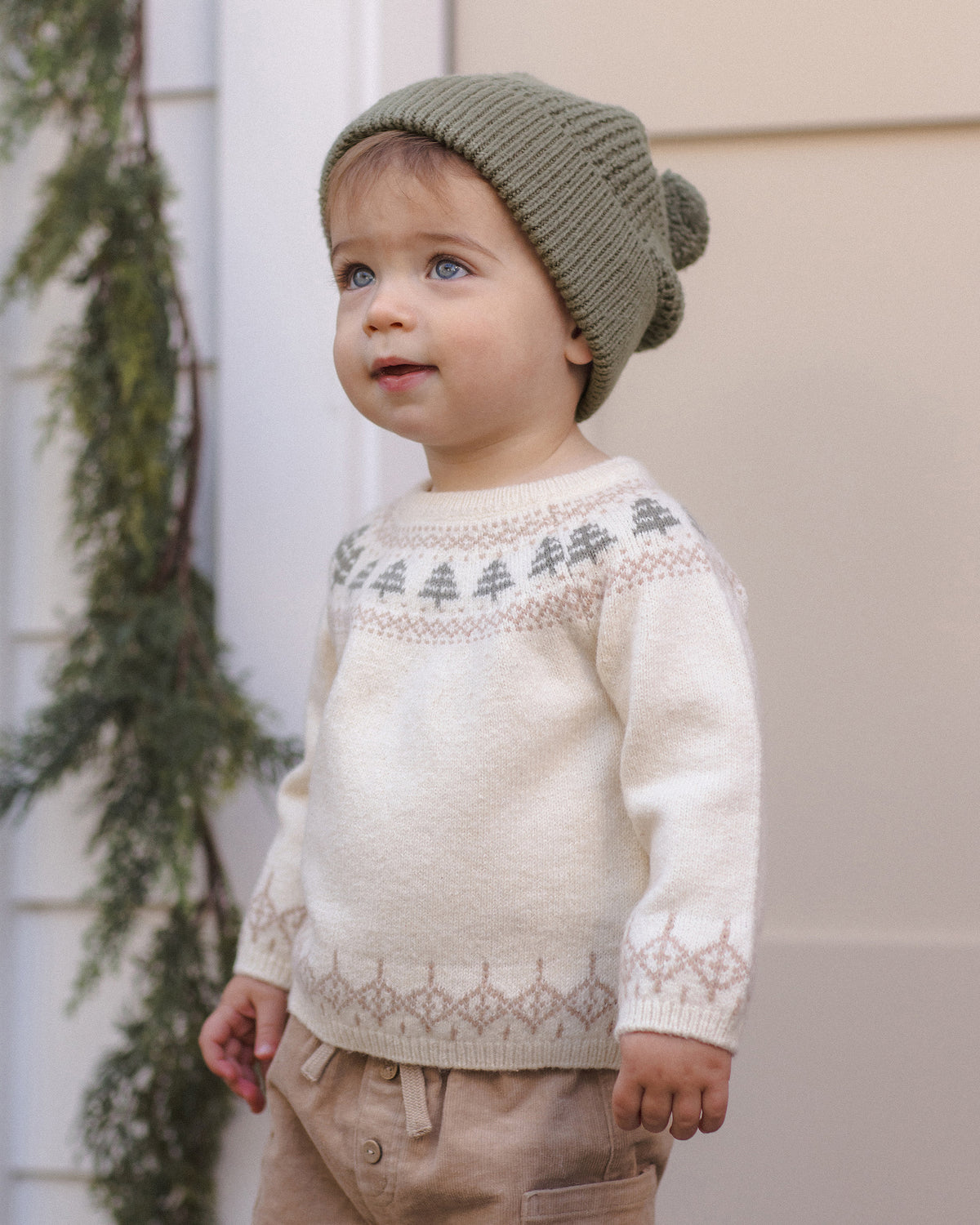 Toddler model wearing Quincy Mae Baby Rex Sweater in Tree Fair Isle and Quincy Mae Beanie in Spruce portrait photo