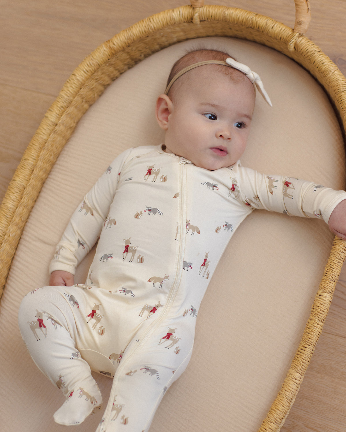 Baby girl model wearing Quincy Mae Baby Bamboo Zip Footie in Forest Friends