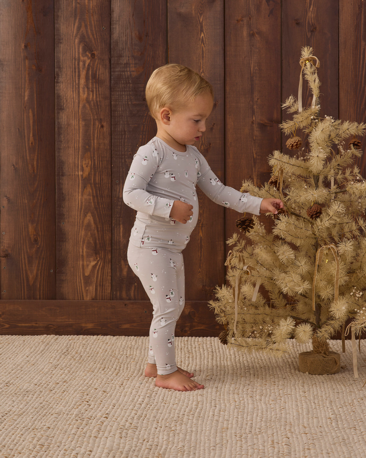 Side angle styled studio model wearing Quincy Mae Baby Bamboo Pajama Set in Snowman