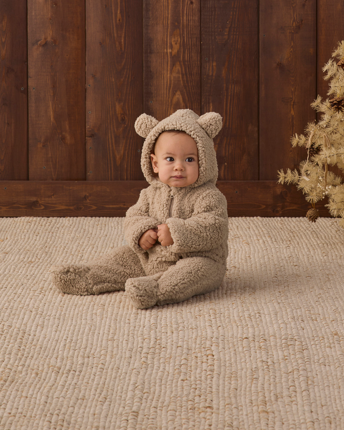 Studio baby model sitting wearing Quincy Mae Baby Bear Jumpsuit in Latte
