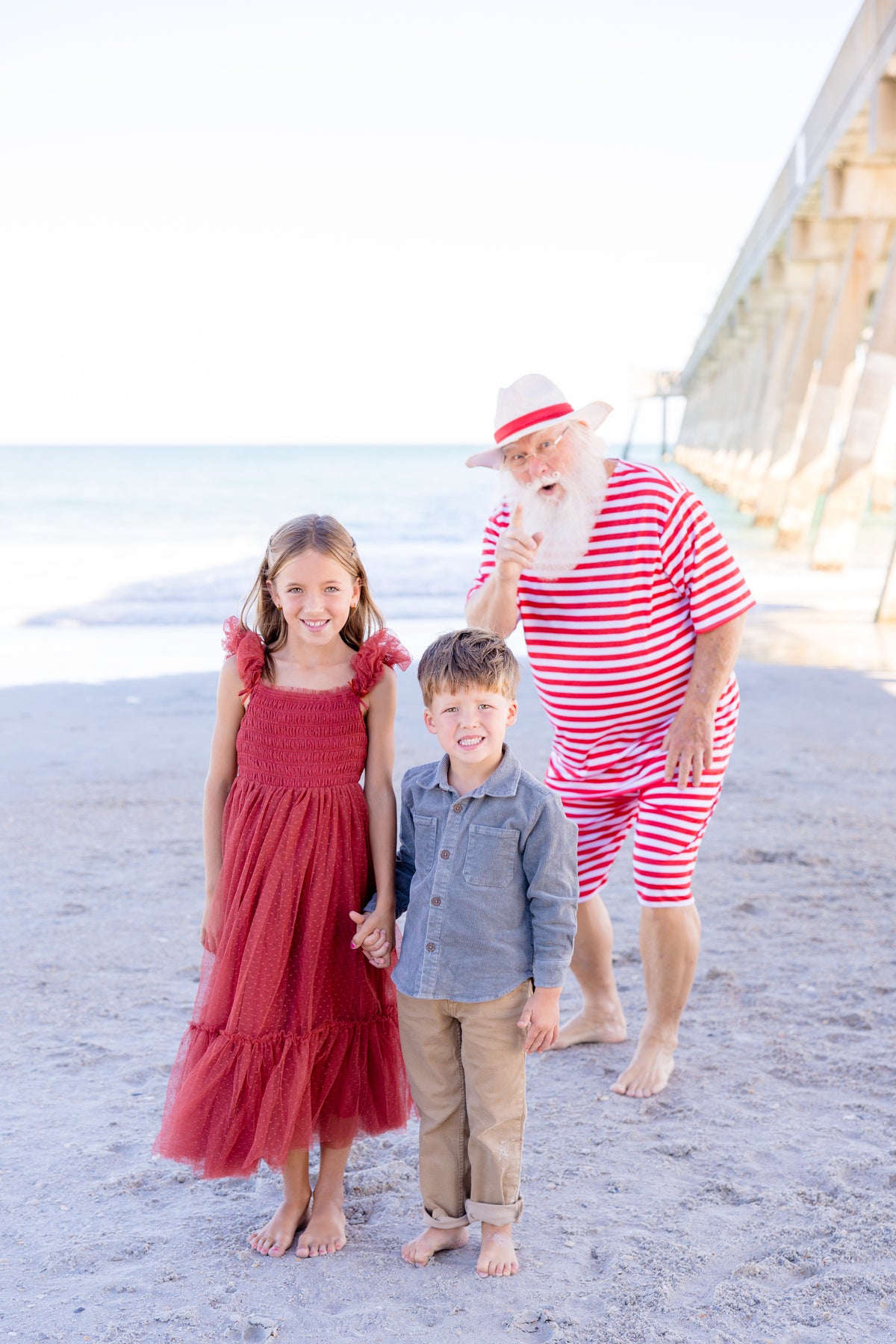 girl holding little boys hand in Noralee Ruby Red dress