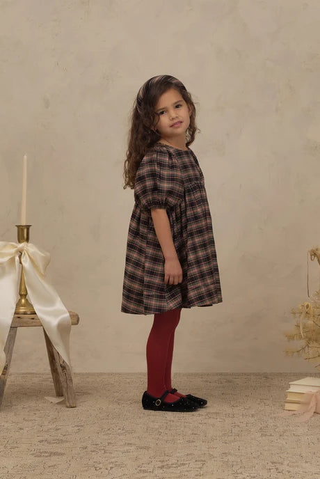 Girl wearing Noralee shimmer tights in "ruby"