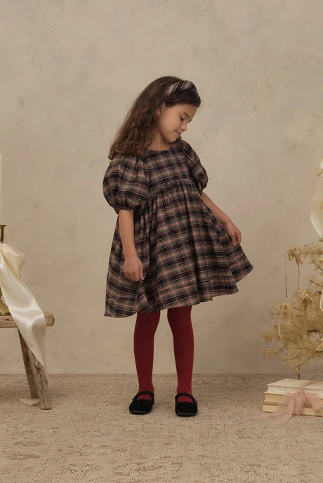 Girl wearing Noralee shimmer tights in "ruby"