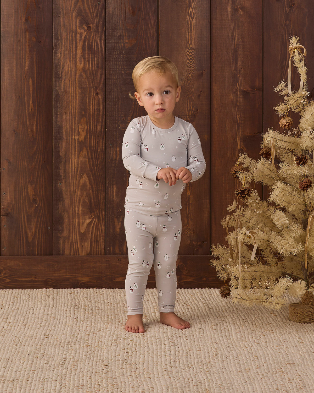 Baby wearing Quincy Mae Baby Bamboo Pajama Set in Snowman styled studio photo