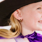 Girl wearing Pierced Co. Halloween Checkered Huggies close up detail