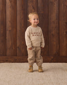 baby boy Knit Baby Toddler Sweater in Santa Baby and Quincy Mae Luca Pant in Latte studio model full length photo
