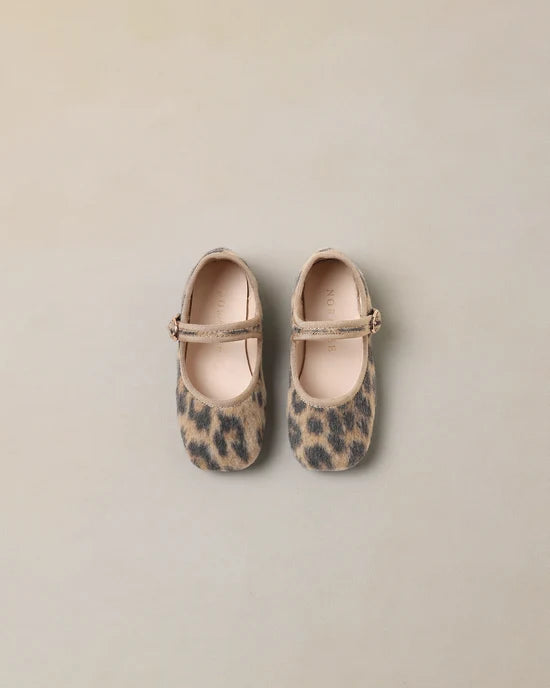 A pair of toddler Mary Jane shoes in a beige and brown leopard print, shown from a top-down view on a neutral beige background.
