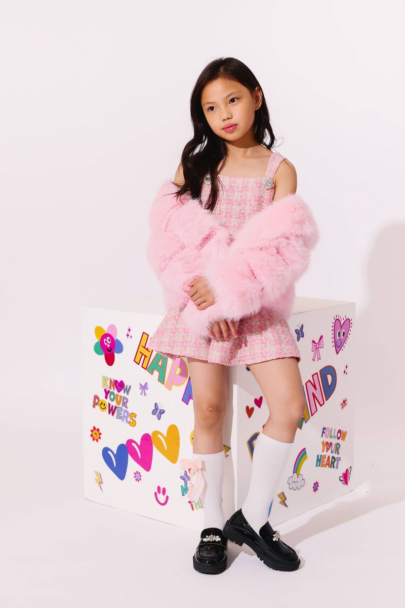 Young girl wearing the Lola and the Boys Cotton Candy Gem Faux Fur styled off-the-shoulder