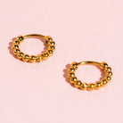 Gold tiny dot huggies earrings hypoallergenic, plated, pierced. Pierced Co. Tiny Dot Huggies flat lay