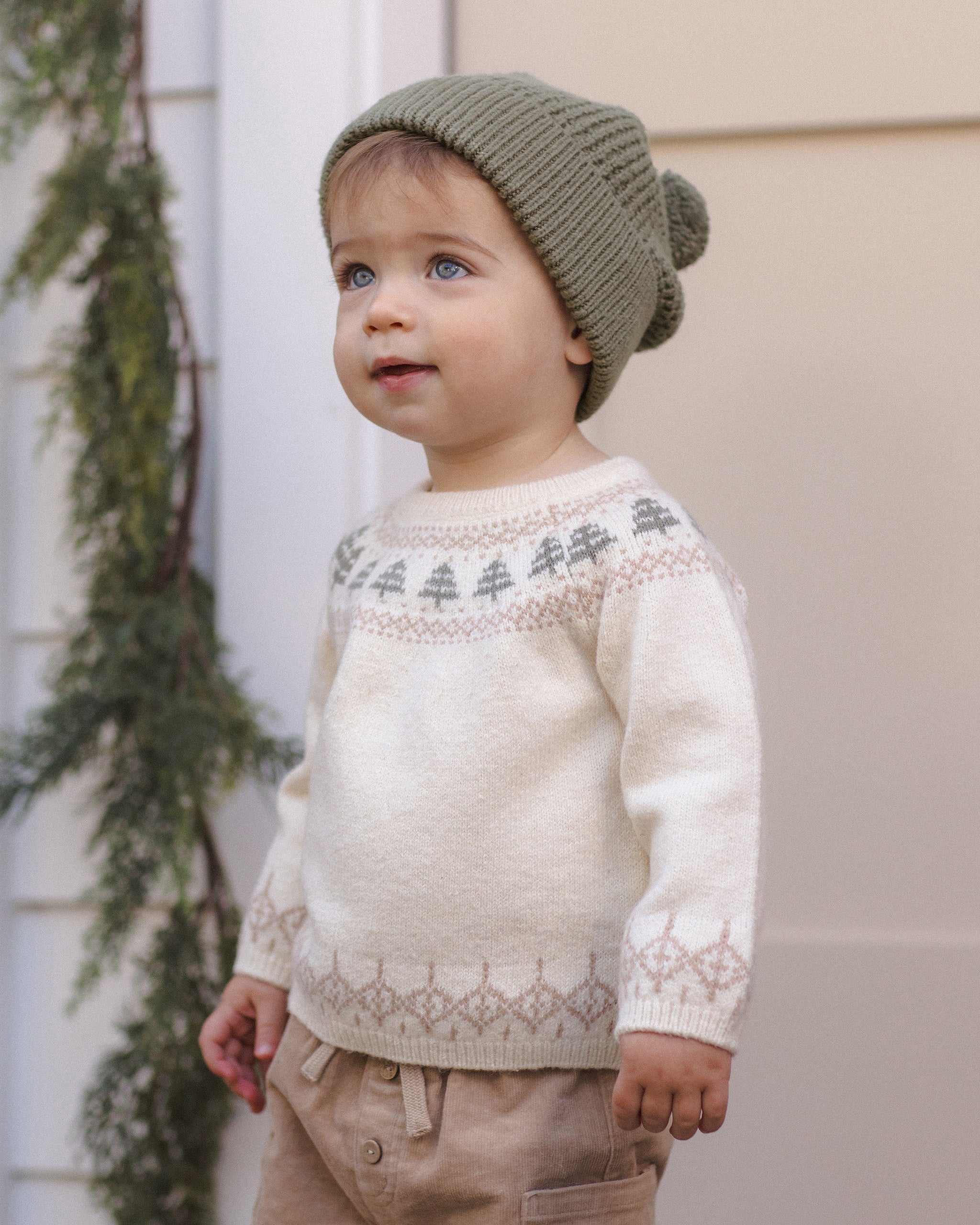 Toddler model wearing Quincy Mae Baby Rex Sweater in Tree Fair Isle and Quincy Mae Beanie in Spruce portrait photo