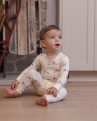 Baby model wearing Quincy Mae Baby Bamboo Pajama Set in Forest Friends full length lifestyle photo