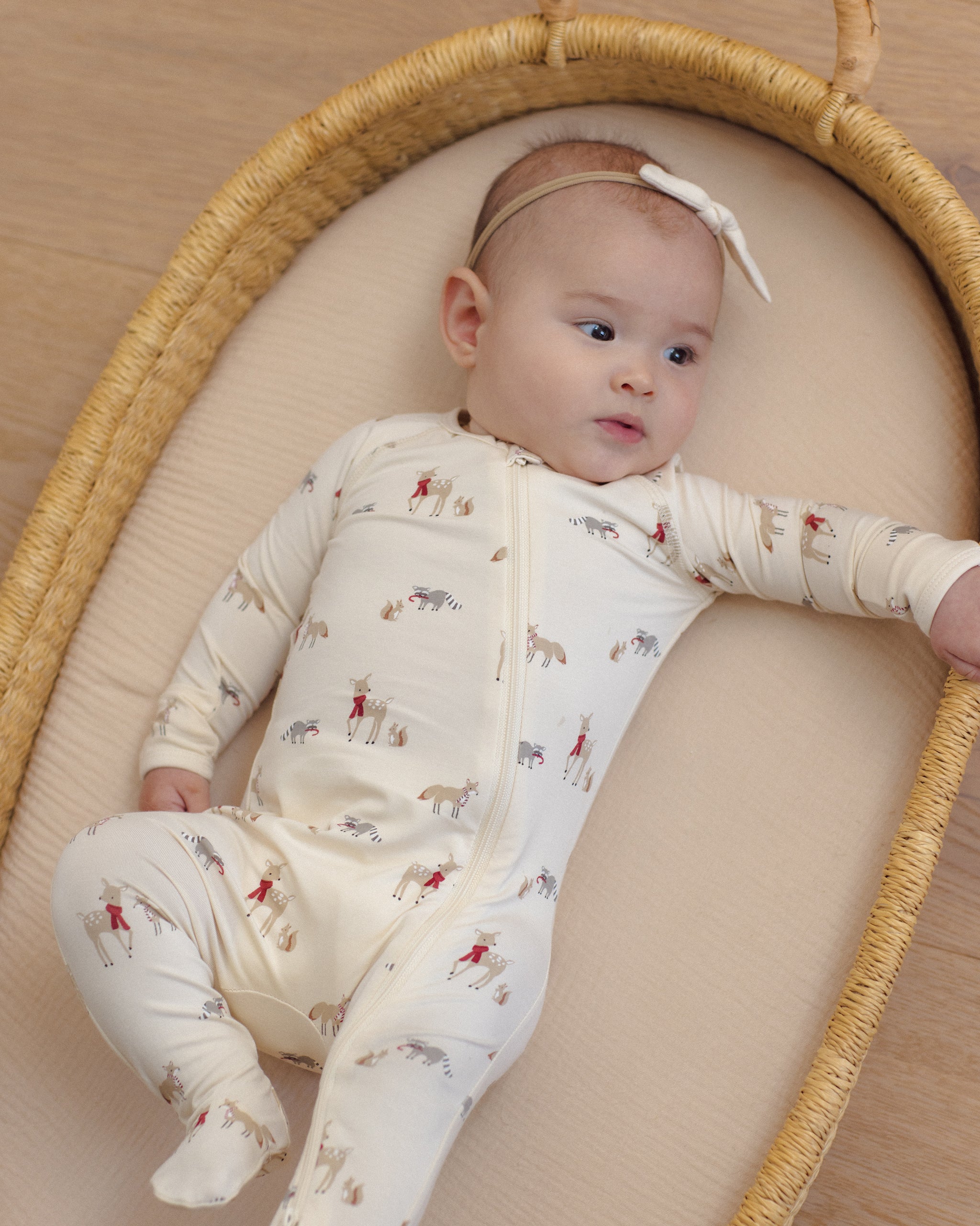 Baby girl model wearing Quincy Mae Baby Bamboo Zip Footie in Forest Friends