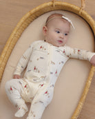 Baby girl model wearing Quincy Mae Baby Bamboo Zip Footie in Forest Friends
