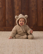 Smiling baby wearing Quincy Mae Baby Bear Jumpsuit in Latte studio photo