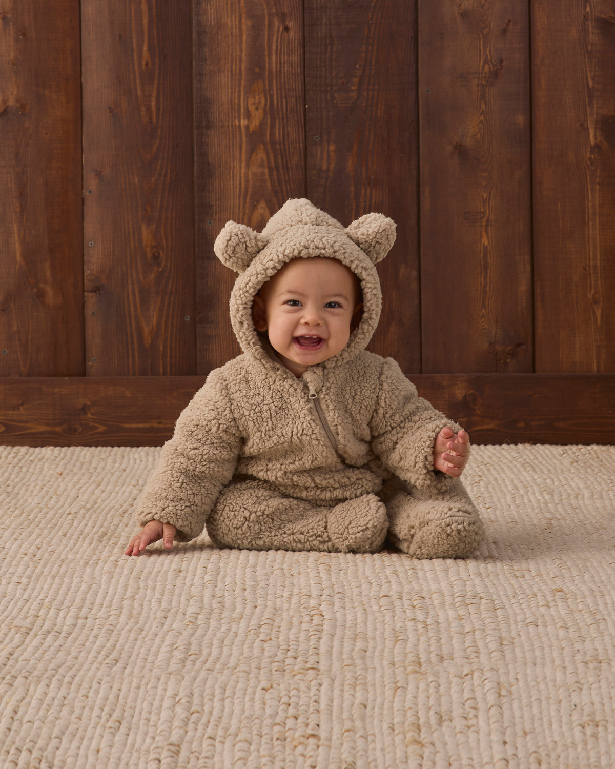 Smiling baby wearing Quincy Mae Baby Bear Jumpsuit in Latte studio photo