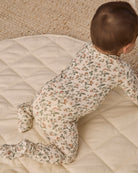 Back to camera angle baby model wearing Quincy Mae Baby Bamboo Zip Footie in Holiday Floral 