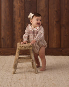 Quincy Mae Baby Callie Romper in Christmas Plaid studio baby model photo styled with Quincy Mae Baby Crochet Bow in Natural