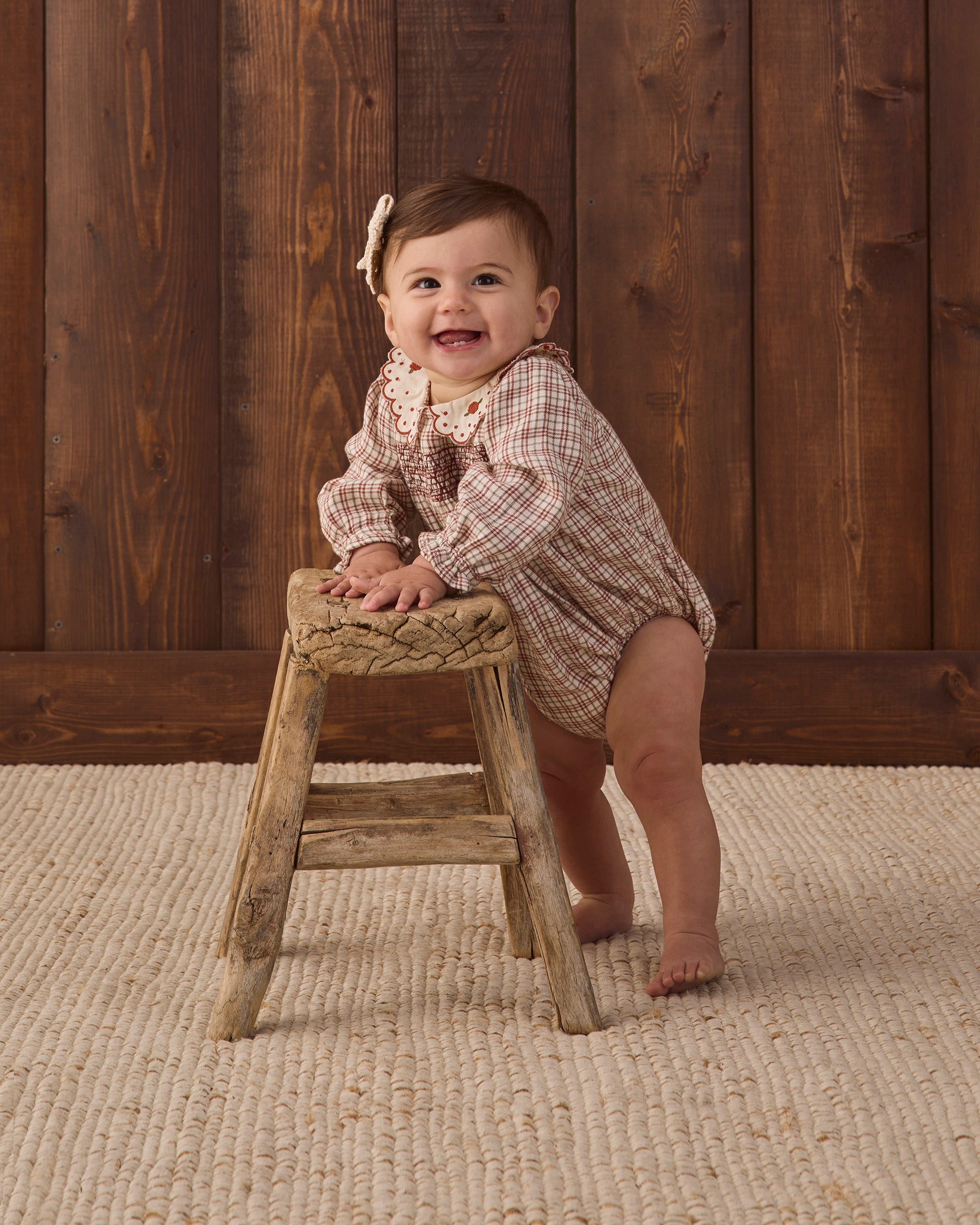Quincy Mae Baby Callie Romper in Christmas Plaid smiling baby model studio photo