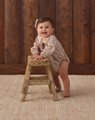 Quincy Mae Baby Callie Romper in Christmas Plaid smiling baby model studio photo