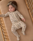 Sleeping baby girl wearing Quincy Mae Baby Bamboo Zip Footie in Holiday Floral 