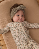 Baby girl wearing Quincy Mae Baby Bamboo Zip Footie in Holiday Floral 