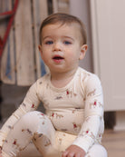 Baby model wearing Quincy Mae Baby Bamboo Pajama Set in Forest Friends lifestyle portrait