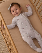 Smiling baby girl wearing Quincy Mae Baby Bamboo Zip Footie in Snowman