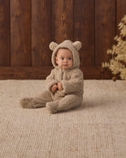 Studio baby model sitting wearing Quincy Mae Baby Bear Jumpsuit in Latte