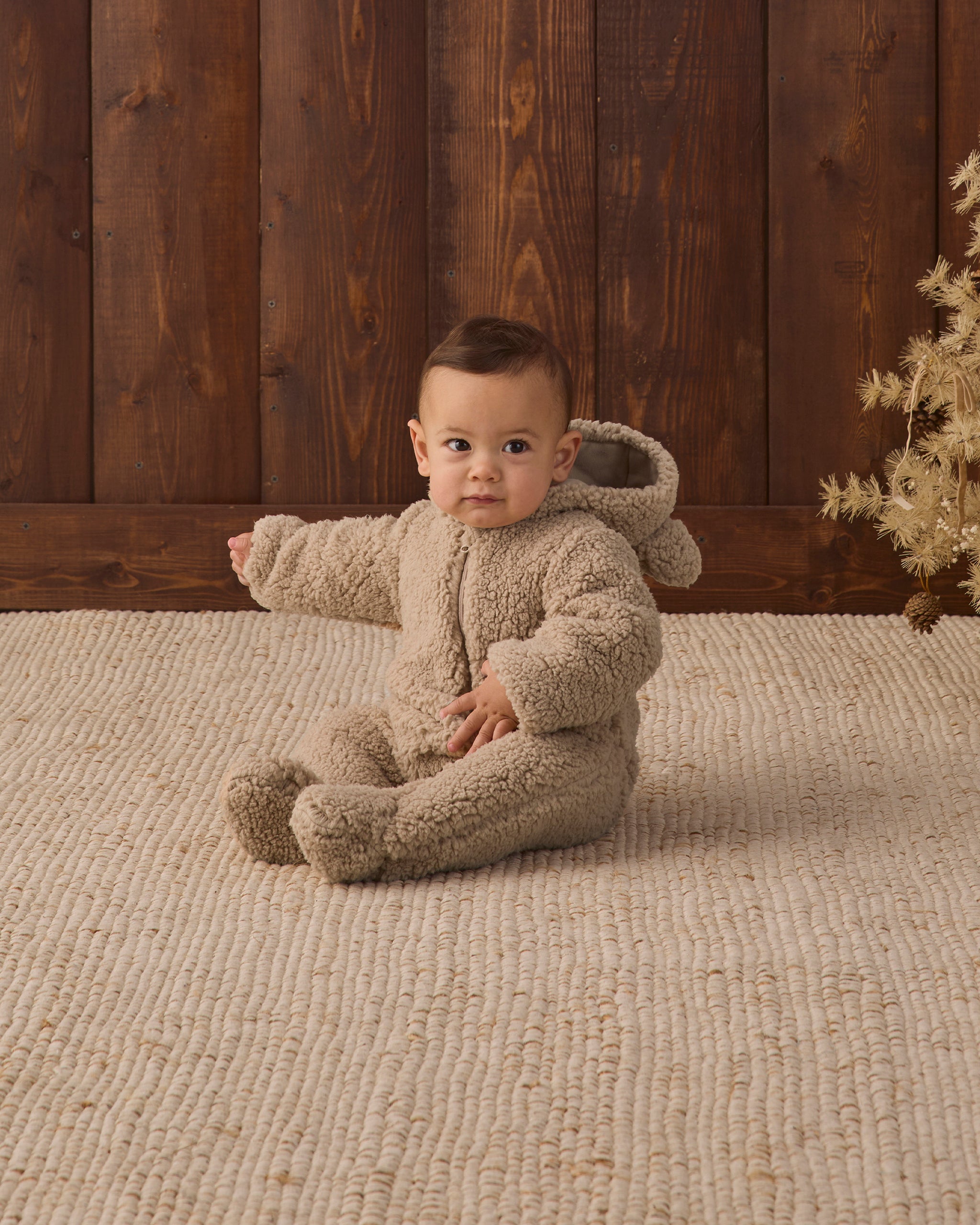 Baby model showing hood of Quincy Mae Baby Bear Jumpsuit in Latte