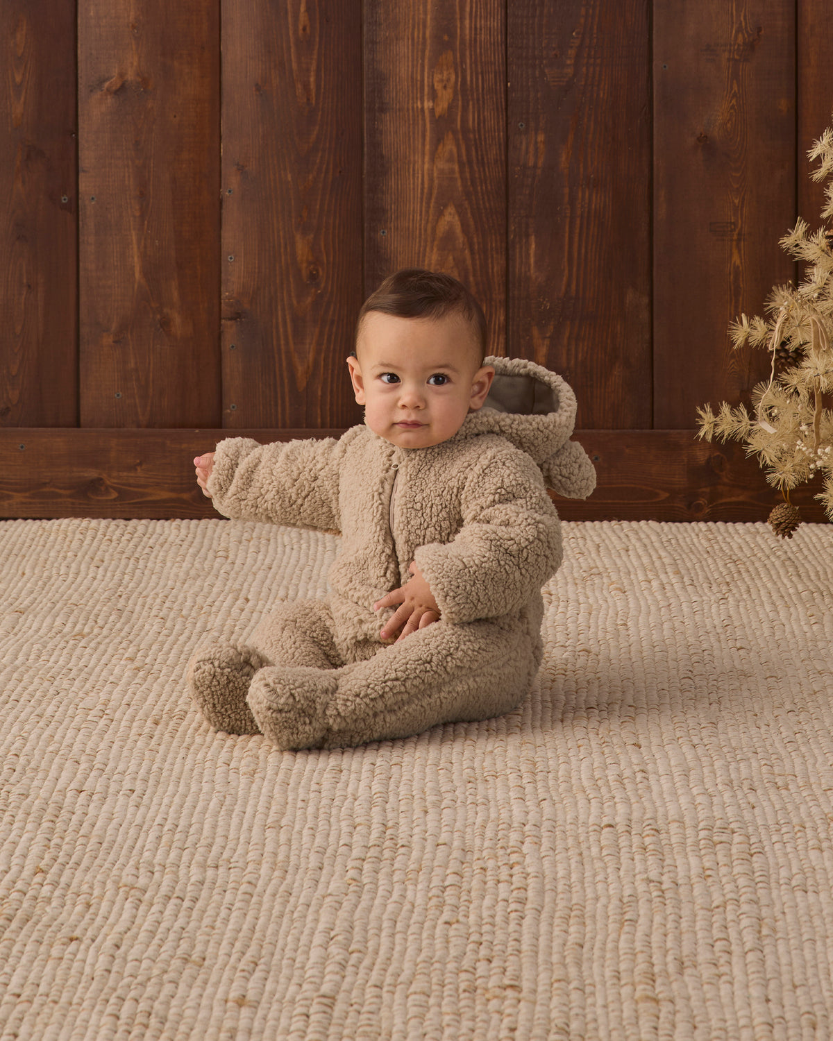 Baby model showing hood of Quincy Mae Baby Bear Jumpsuit in Latte