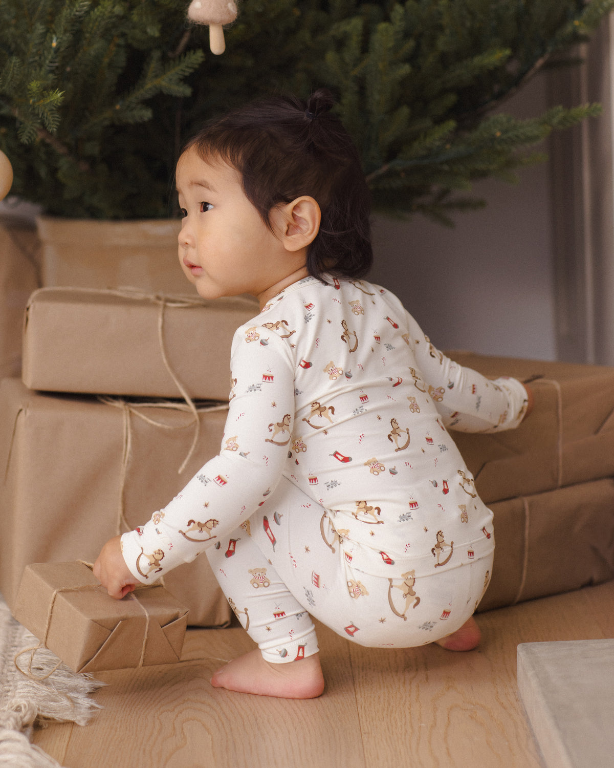 Quincy Mae Bamboo Baby Pajama Set in Toy Chest baby model lifestyle portait back to camera angle
