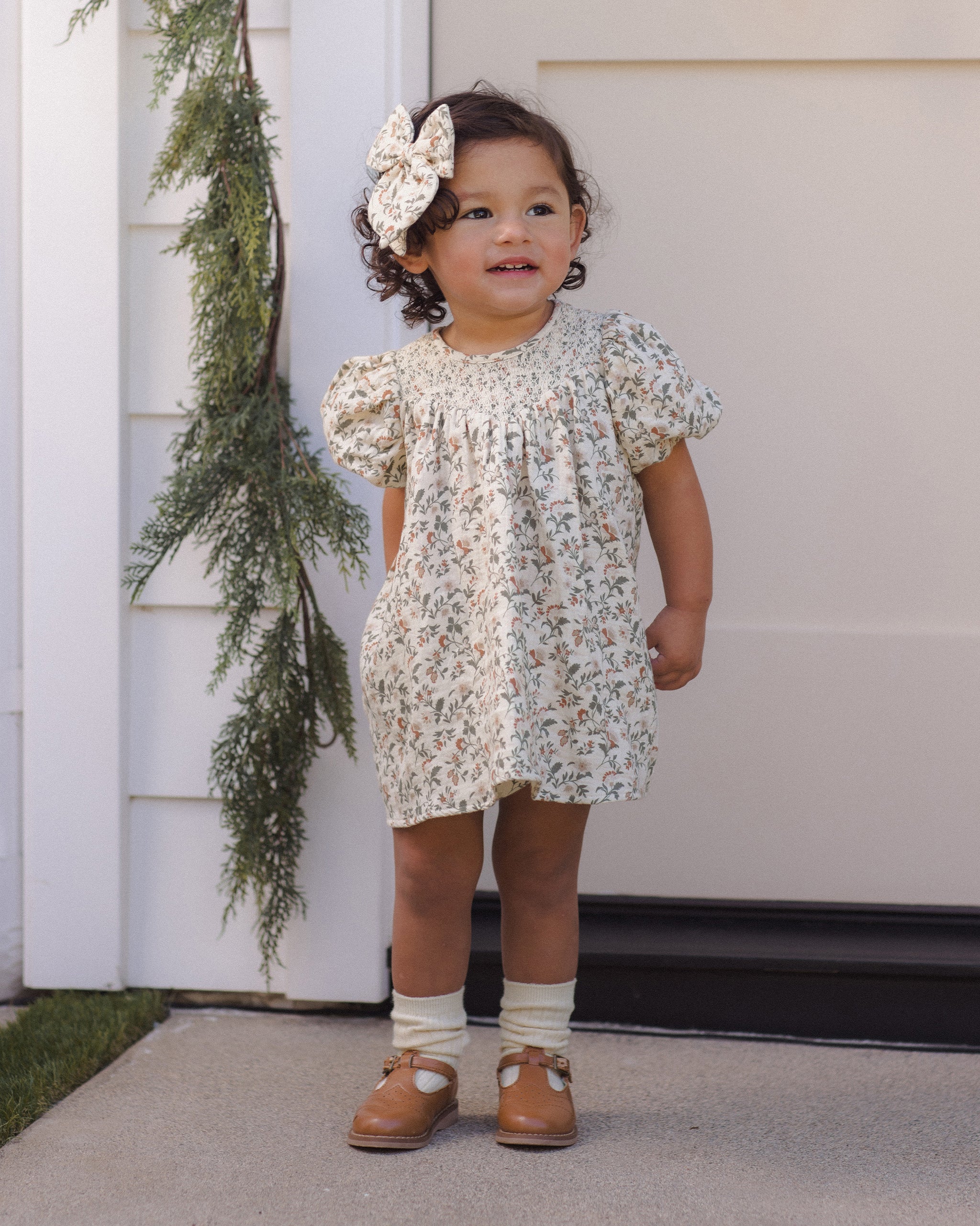 Quincy Mae Carina Baby Dress in Holiday Floral full length lifestyle model photo