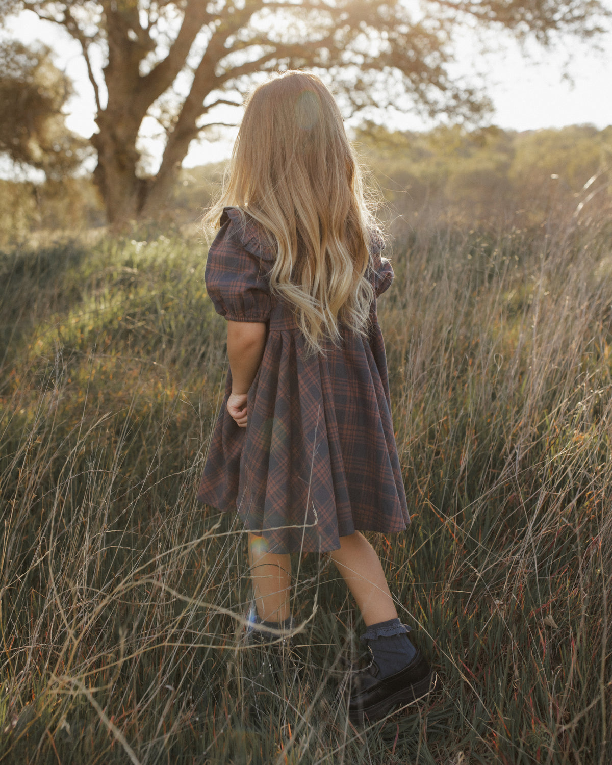 Back view of a girl modeling the Rylee + Cru Camille Dress | Midnight Plaid
