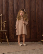 Girl wearing the Rylee + Cru Collette Mini Dress | Fawn Gingham styled with the matching bow