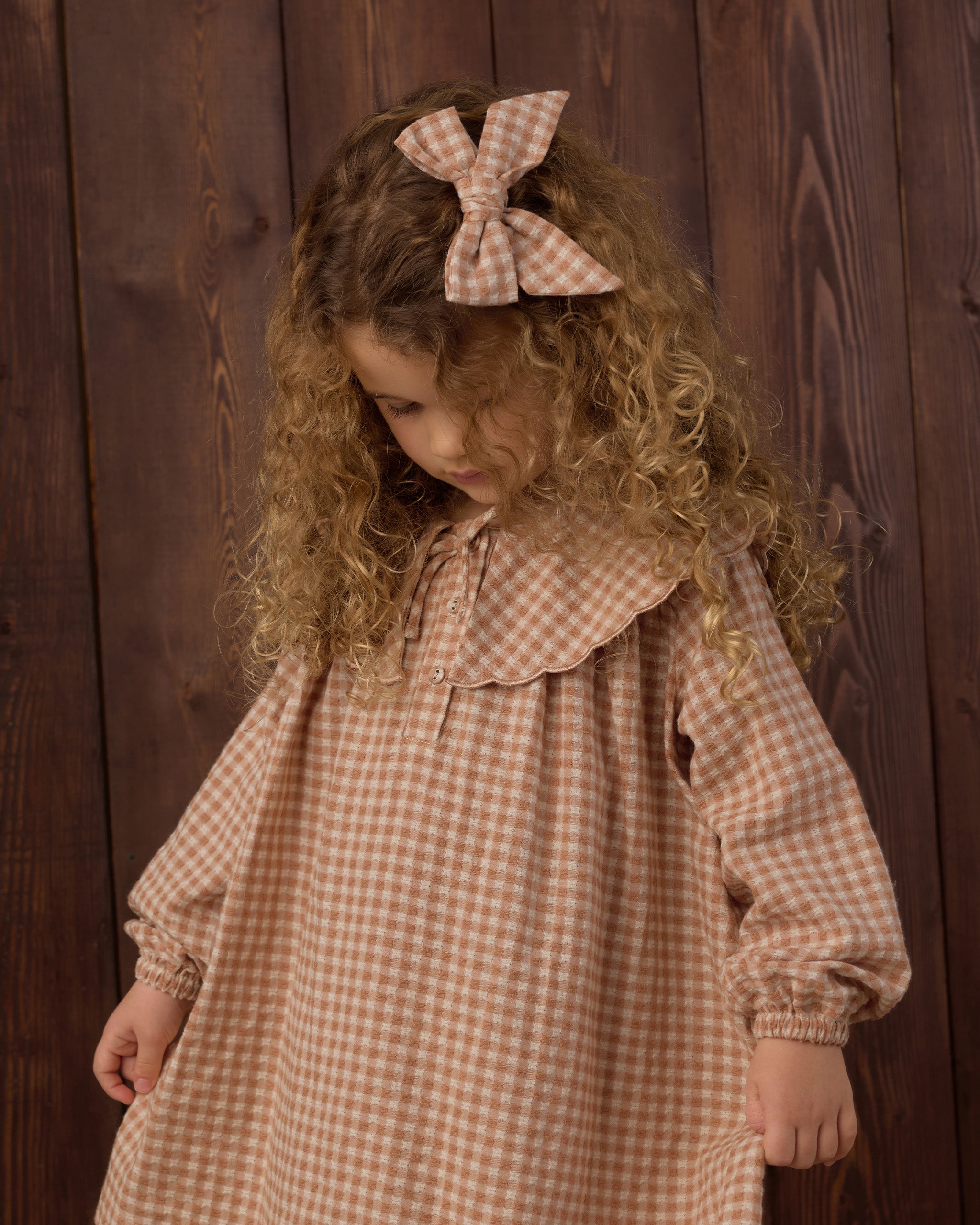 Girl wearing the Rylee + Cru Collette Mini Dress | Fawn Gingham and showing off the coordinating matching bow