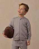 Close-up shot of boy modeling the Rylee + Cru Tech Hoodie | Heathered Dusty Blue