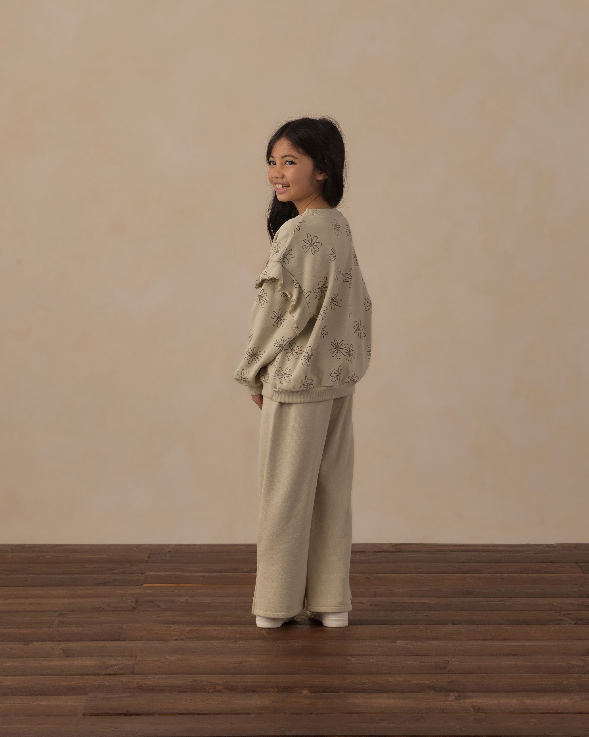 Girl wearing the Ruffle Sweatshirt | Big Daisy from Rylee + Cru, rear shot, looking over her shoulder