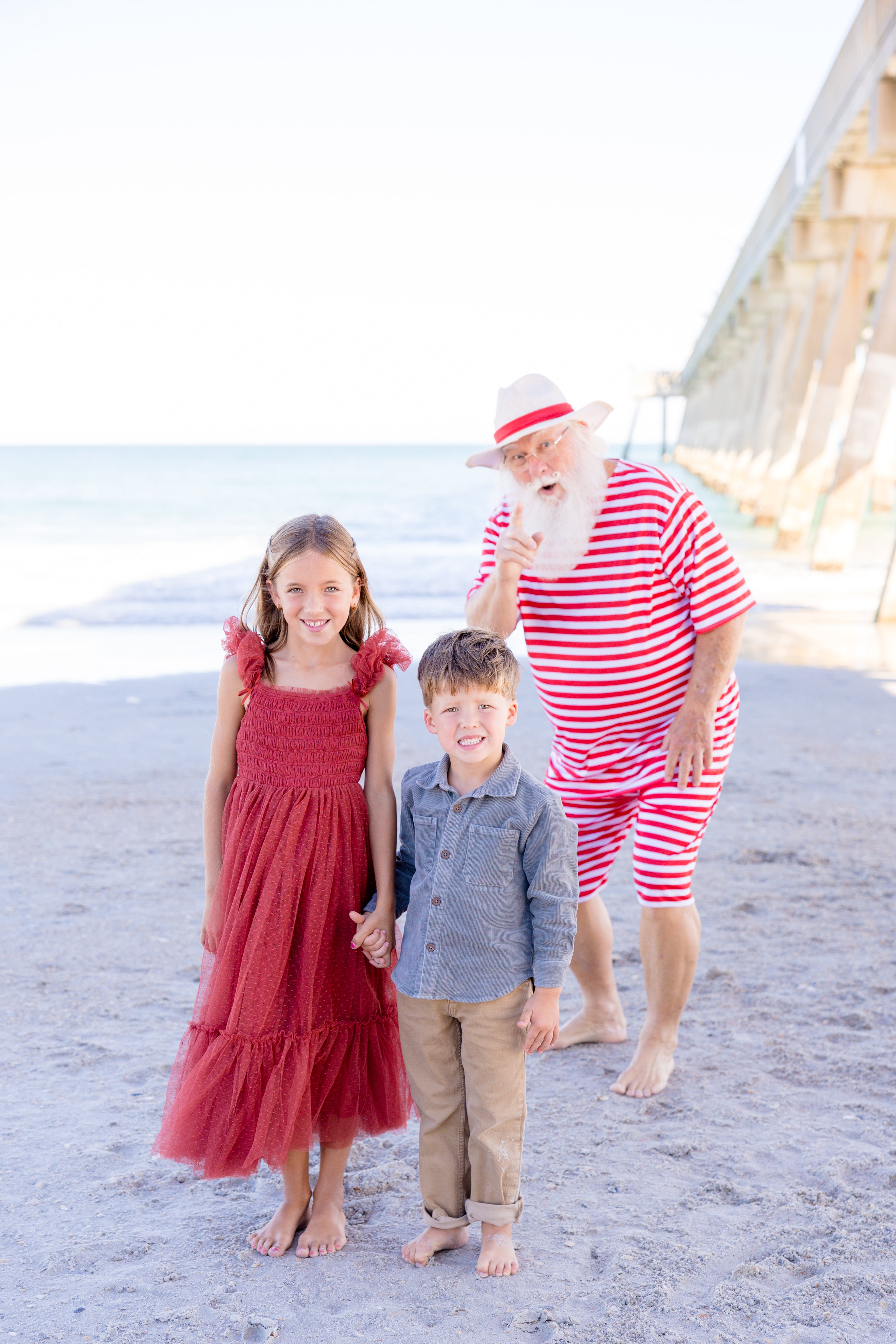 girl holding little boys hand in Noralee Ruby Red dress 