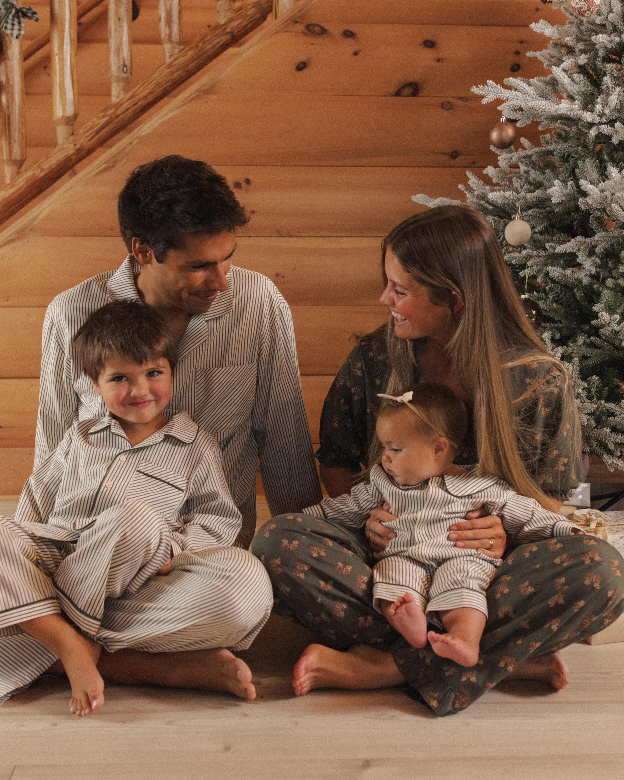 Model lifestyle shot Rylee + Cru Men's Pajama Pant | Evergreen Stripe Family Matching Holiday Pajamas and Rylee + Cru Boy's Long Sleeve Pajamas | Evergreen Stripes