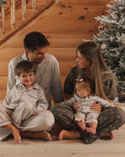 Model lifestyle shot Rylee + Cru Men's Pajama Pant | Evergreen Stripe Family Matching Holiday Pajamas and Rylee + Cru Boy's Long Sleeve Pajamas | Evergreen Stripes