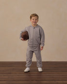 Boy in studio wearing the Rylee + Cru Tech Hoodie | Heathered Dusty Blue