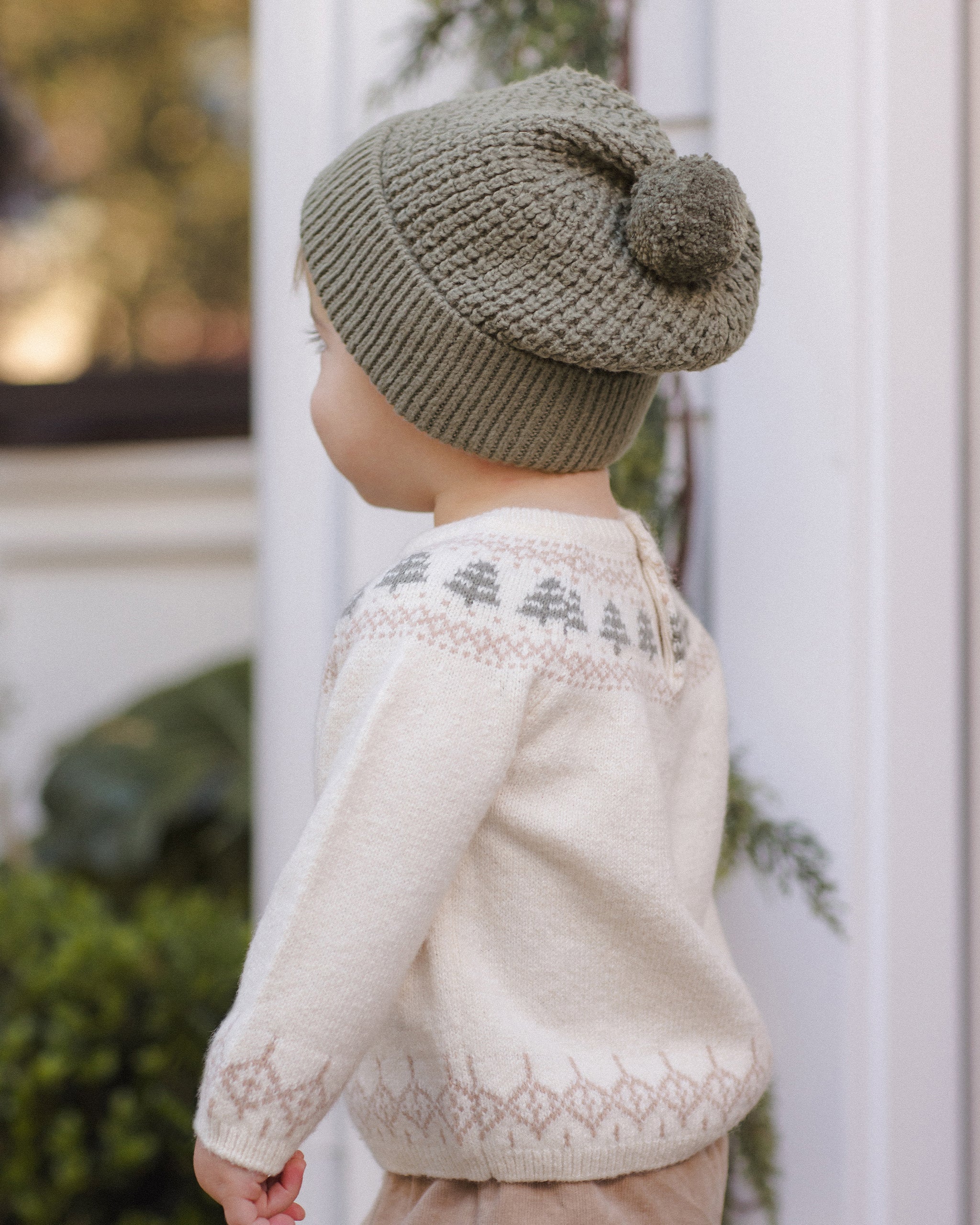 Toddler model wearing Quincy Mae Beanie in Spruce and Quincy Mae Baby Rex Sweater in Tree Fair Isle back to camera photo