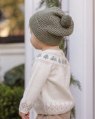 Toddler model wearing Quincy Mae Beanie in Spruce and Quincy Mae Baby Rex Sweater in Tree Fair Isle back to camera photo