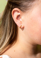 Pierced Co. Tiny Dot Huggies flat lay earring on model close up