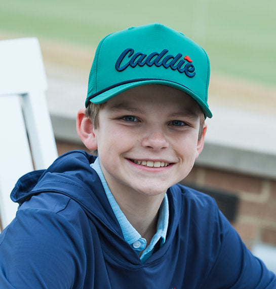Youth model wearing Youth Caddie Performance Rope Hat | Green & Navy lifestyle model portrait photo